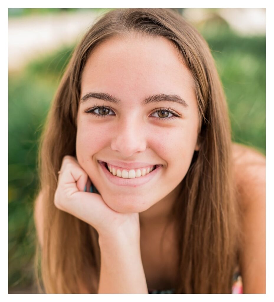 teen smiles with retainer on teeth