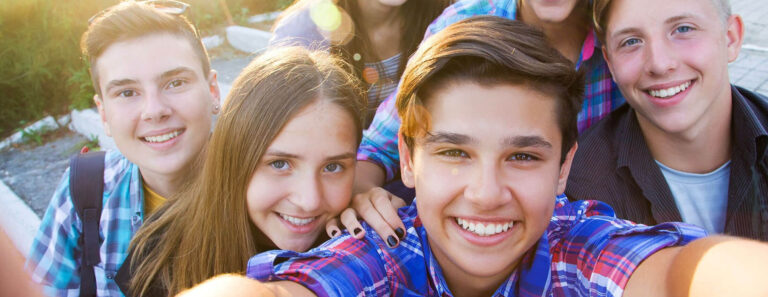 teens pose together for a photo after learning braces vs Invisalign pros and cons